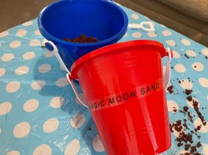 Two buckets full of colourful sand