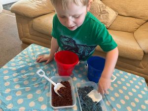Playing with moon sand using a bucket and spade 
