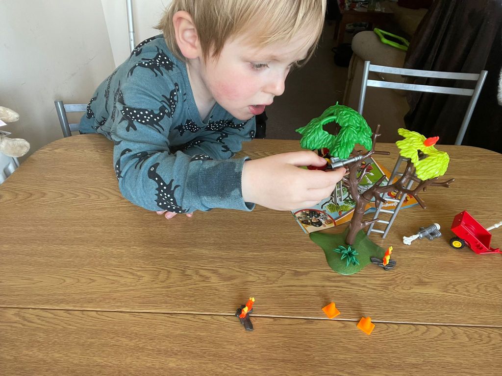 Carefully building his playset