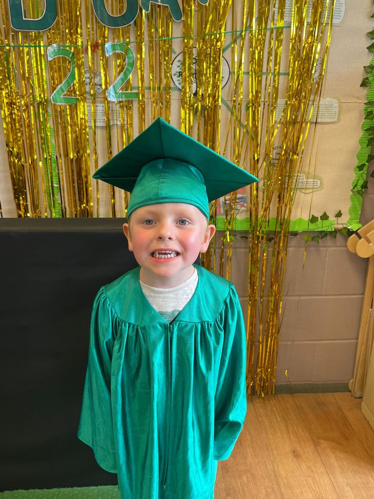 Proudly smiling at Nursery graduation ceremony
