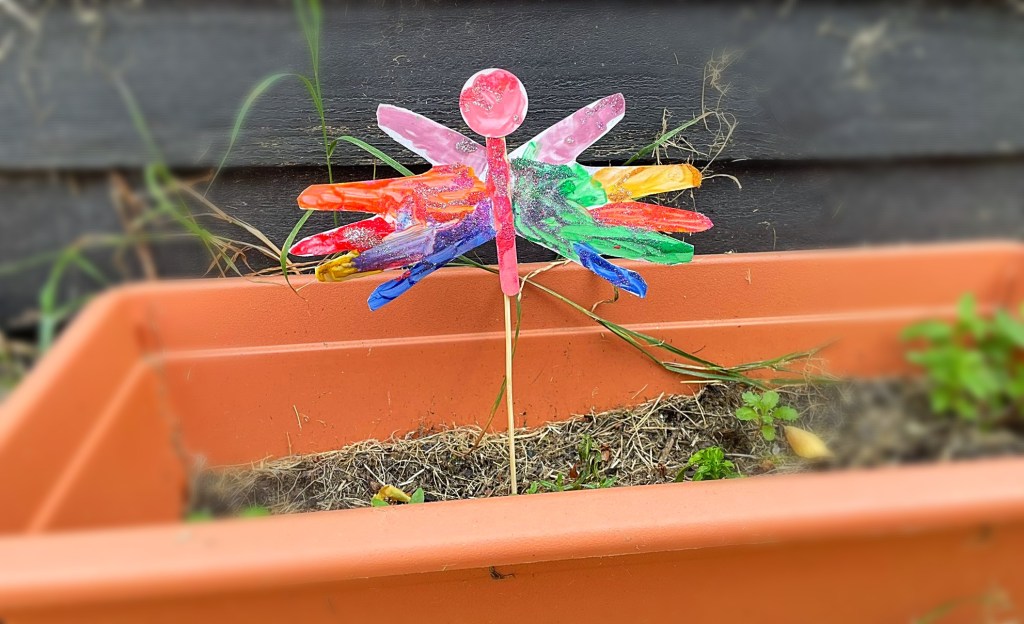 Our butterfly handprint sitting happily in a flower bed